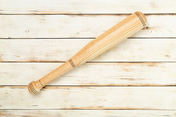 Wooden baseball bat on wooden background, top view