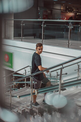 Handsome young man of European appearance in a black T-shirt in a shopping center on the street