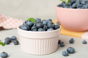 Bowl with fresh bright blueberries on wooden table