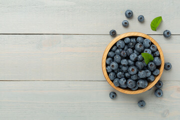 Bowl with fresh bright blueberries on wooden background,top view