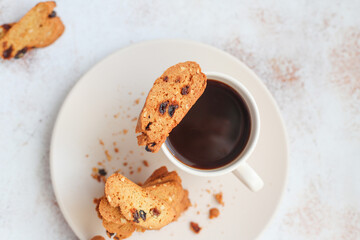 Italian raisin almond biscotti and glass of milk on light background.