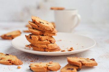 Italian raisin almond biscotti and glass of milk on light background.
