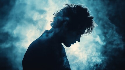 Dramatic silhouette of man in blue backlight with moody atmospheric smoke