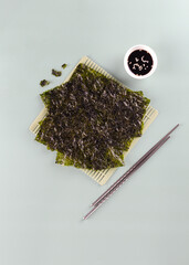 Asian crispy snack made from nori seaweed napkins on blue background. Top view © Amore Sea