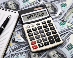 A professional business scene showing a calculator displaying the word "INFLATION" on a pile of hundred-dollar bills, symbolizing economic issues and financial calculations.