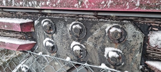 Metal bolts on foot bridge in winter with cold rime closeup