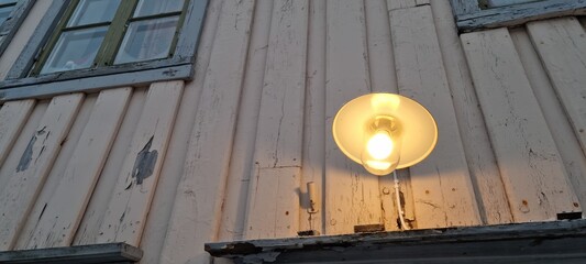 old fashioned porch ligh on weathered building wall