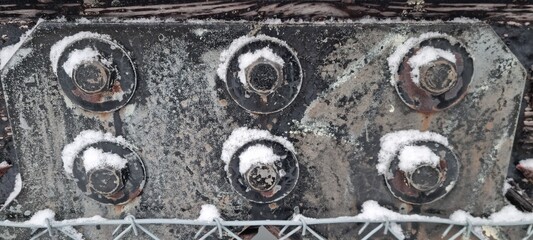 Metal bolts on foot bridge in winter with cold rime closeup