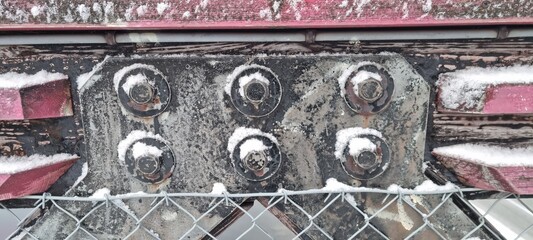 Metal bolts on foot bridge in winter with cold rime closeup