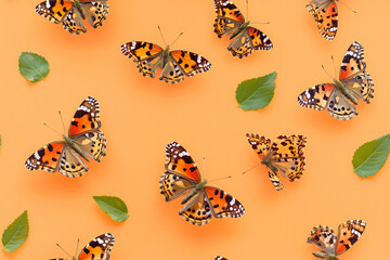 seamless background pattern of painted lady butterflies in natural warm-toned arrangement 
