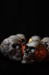 Halloween skulls with glowing pumpkins on dark spooky background