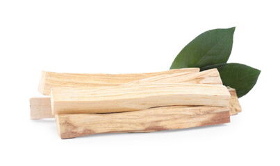 Pile of palo santo sticks and green leaves on white background