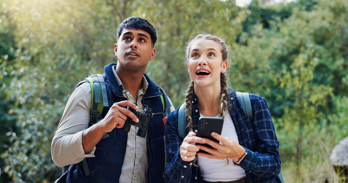 Hiking, bird watching and couple with cellphone, internet and fitness with hobby, nature and break. People, outdoor and man with woman, binoculars and smartphone with journey, adventure and excited