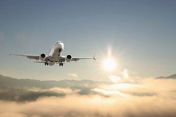 Airplane flying over mountains on sunny morning