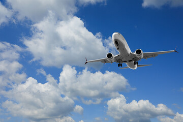 Airplane flying in beautiful blue sky with clouds