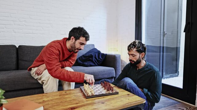 Gay couple playing chess at home