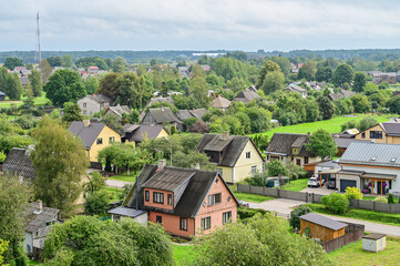 Obraz premium Panoramic view of the historic town of Kuldiga, featuring houses, streets, trees, and fields in a summer landscape, Kurland, Latvia