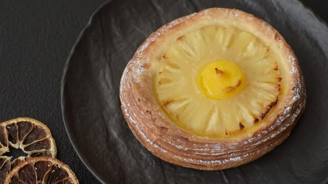 Sweet round tart with pineapple on a dark concrete background