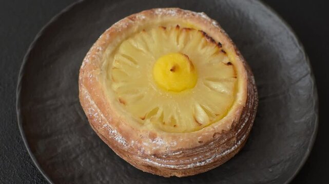 Sweet round tart with pineapple on a dark concrete background