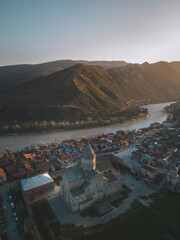 Mtskheta Church, view of the city on a sunset, aerial view, flying straight
