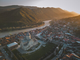 Mtskheta Church, view of the city on a sunset, aerial view, flying straight