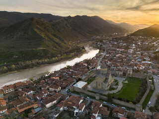 Mtskheta Church, view of the city on a sunset, aerial view, flying straight