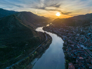 Mtskheta Church, view of the city on a sunset, aerial view, flying straight