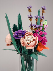 Naklejka premium Prague, Czech republic - February 20, 2025: Colorful lego flower bouquet in glass vase, celebrating creativity and playfulness