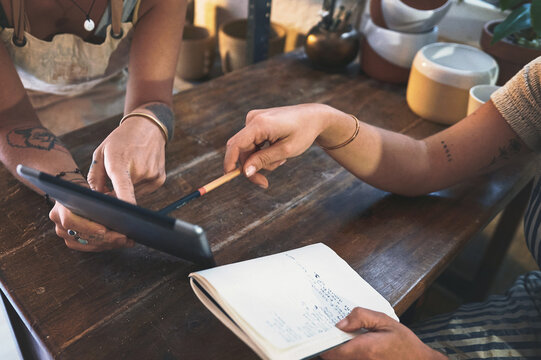 Workshop, hands and people on tablet at pottery shop on notebook for logistics checklist. Business, planning or teamwork at startup on internet for online post strategy, blog engagement or art supply