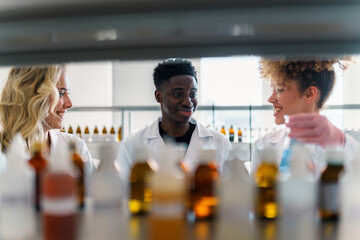 Diverse university students in lab coats collaborating with their professor on research projects, conducting experiments and analyzing samples in a modern laboratory
