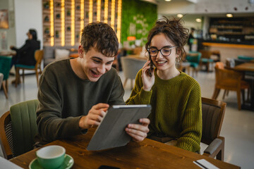 Fototapeta premium couple learn together and prepare exam on digital tablet at cafe