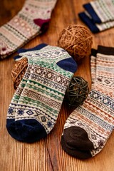 A socks displayed on a table. The socks are likely made of knitted textile, showcasing various patterns. This indoor setting suggests a cozy atmosphere, typical for items related to clothing 