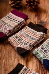 A socks displayed on a table. The socks are likely made of knitted textile, showcasing various patterns. This indoor setting suggests a cozy atmosphere, typical for items related to clothing 