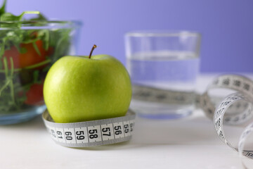 Embracing a Healthy Lifestyle A Fresh Green Apple with a Colorful Salad and Measuring Tape