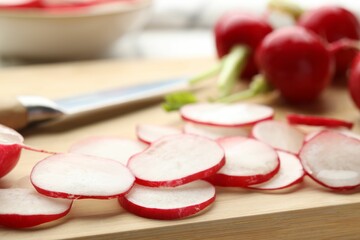 Slices of fresh radishes on wooden board, closeup