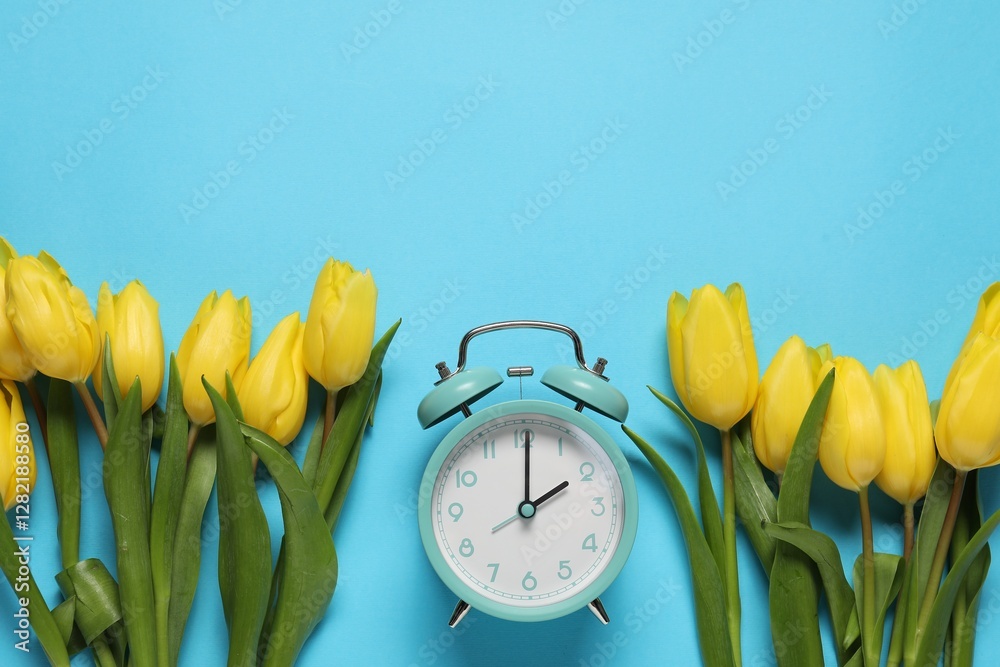Poster spring time. alarm clock and beautiful tulips on light blue background, flat lay. space for text