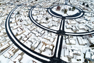 A snow covered neighborhood with houses and a round street