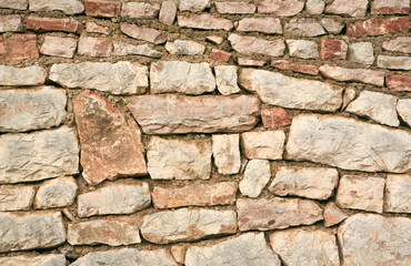 Background of a stone wall made of large stones without mortar, close-up. Stoney texture for publication, design, poster, post, screensaver, wallpaper, cover, website. High quality photo