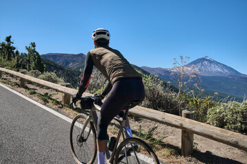 Cyclist enjoying a scenic ride through a mountain pass with stunning views.  Perfect for travel,...