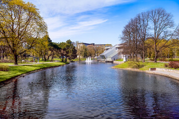 Fototapeta premium Spring awakening in Riga, Latvia, modern city meets green parks, urban architecture, spring renewal in seasonal transition. For travel bloggers, architecture-focused tourism, sustainable city projects