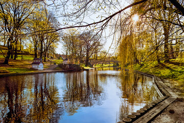 Spring in Riga city park, nature awakening, spring greenery by city canal. Golden hour in downtown....