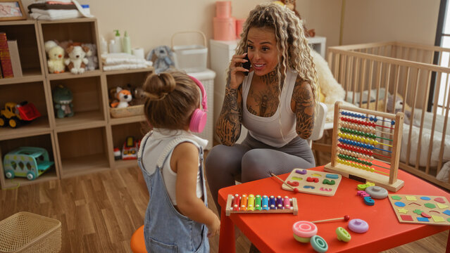 Woman talking on phone in a playroom while girl with headphones listens, surrounded by colorful toys and educational tools, emphasizing family interaction and communication.