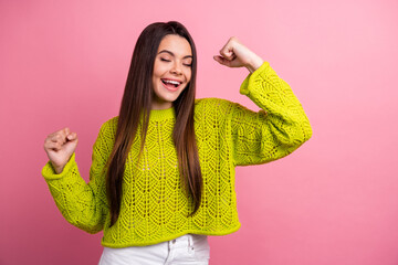 Cheerful Young Woman in Vibrant Green Sweater Posing Joyfully Against a Bright Pink Background