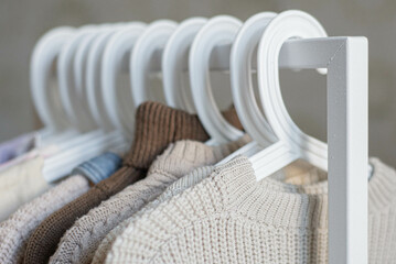 open storage: children's clothes in beige tones hanging on hangers