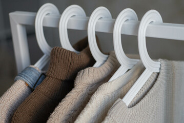 open storage: children's clothes in beige tones hanging on hangers