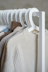 open storage: children's clothes in beige tones hanging on hangers