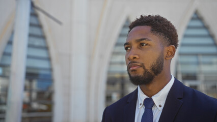 Fototapeta premium Handsome young man standing outdoors on a city street wearing formal attire