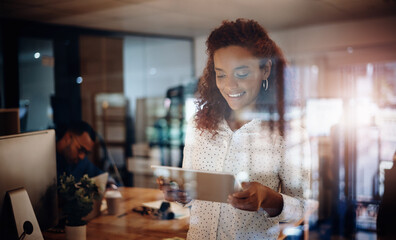 Woman, tablet and night in office by glass with smile for results, overtime or review for project management. Person, touchscreen and application for contact, feedback or good news at creative agency