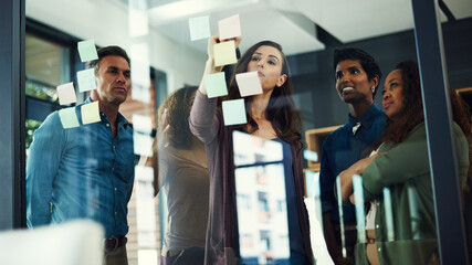 Meeting, sticky notes and writing with business people in office together for brainstorming....