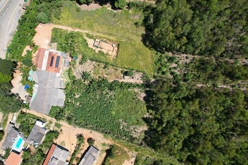 Fototapeta premium Contraste das casas em uma área de expansão urbana sobre a floresta, em uma área localizada no interior do estado de São Paulo, Brasil, em uma imagem aérea obtida com drone.